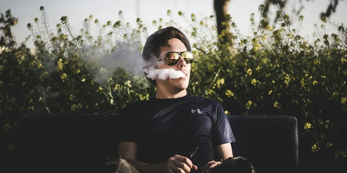 How to Store Disposable Vapes for Optimal Enjoyment man sitting on a bench and vaping relaxed