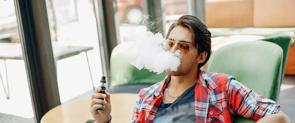 Inside Vape Pod Systems: How Vape Pods Work stylish elegant man sitting cafe with his vaping
