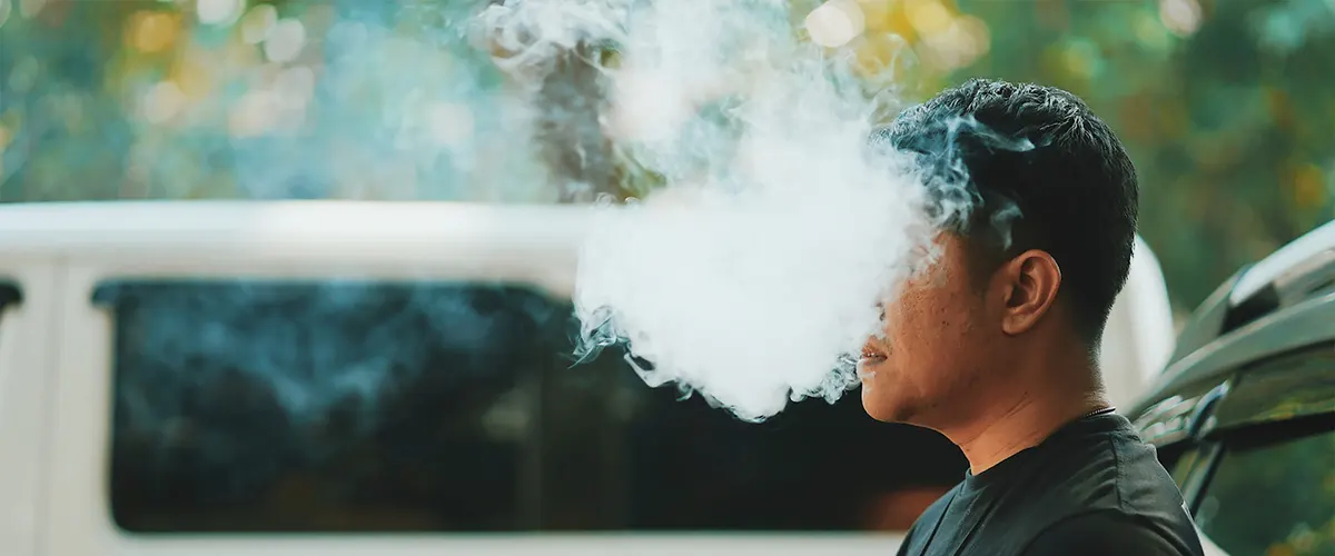 man enjoys vaping casually taking his rechargeable disposable vape