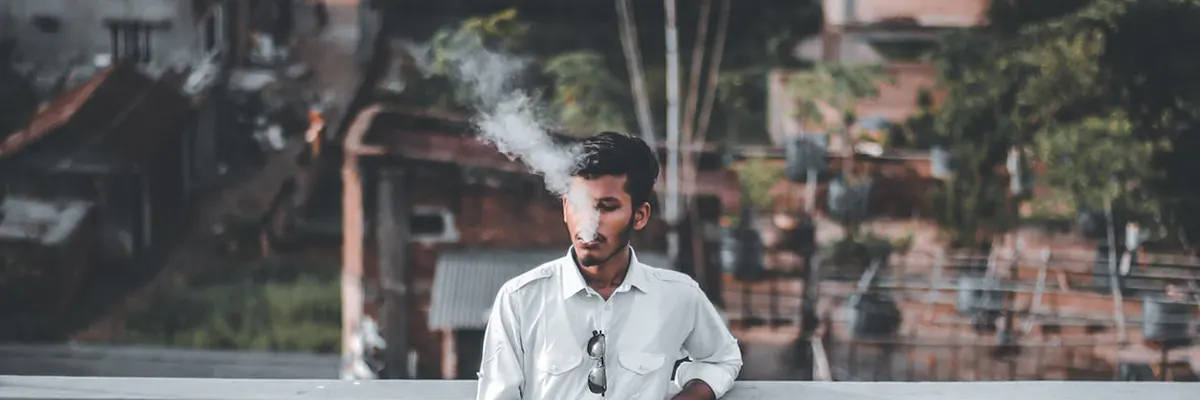 man vaping via rechargeable disposable vape