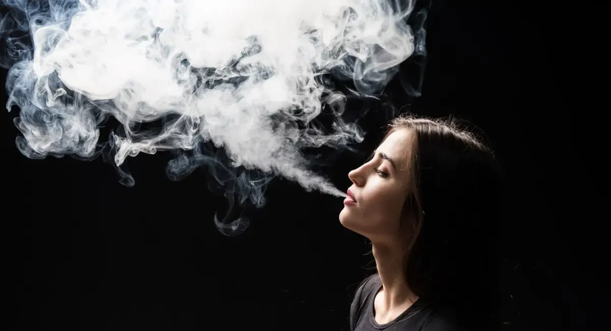 What Does It Mean When a Disposable Vape Blinks? woman vaping e cigarette with cool vapor puffs