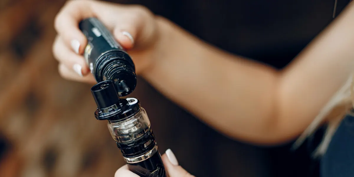 stylish woman fills her favorite pg vg e-liquid to her e-cig
